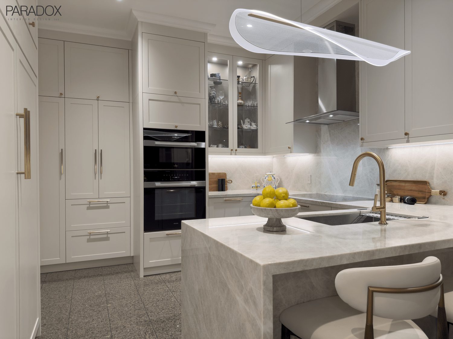 Renovated Bridle Path kitchen in Toronto with white custom cabinetry and Taj Mahal quartzite counters and backsplash, view 2