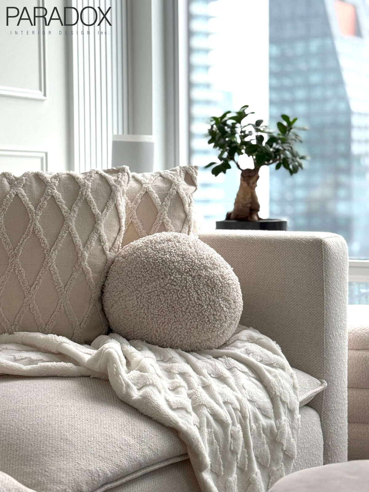 Calm downtown Toronto condo living space in light tones with layered textures, view 3